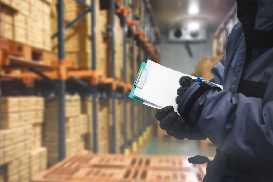 Industriekälteanlagen in Lagerräumen und Lagerhallen: Der Mitarbeiter im Vordergrund braucht Handschuhe.