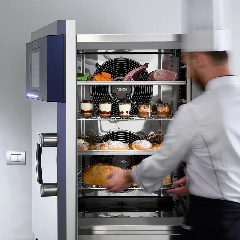 Ein Koch, der Lebensmittel aus einem Schockfroster rausholt, welche frisch bleiben dank einer optimalen Kälte- und Klimatechnik